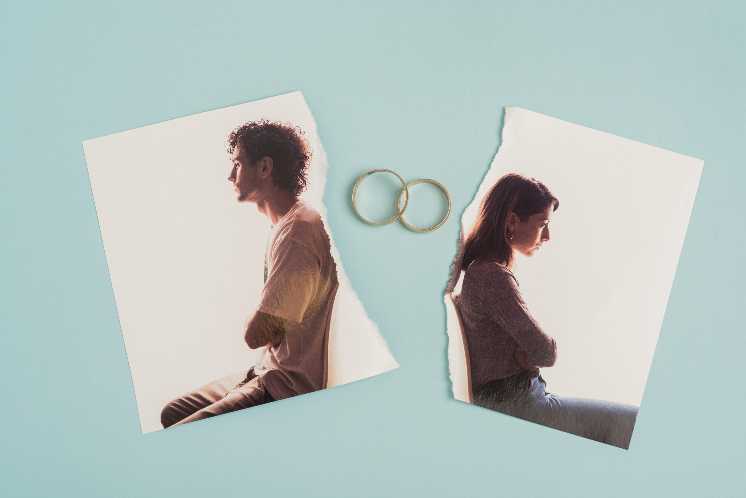 Image of a couple once sitting side by side is split in half, with their marriage rings in between to signify their separation.