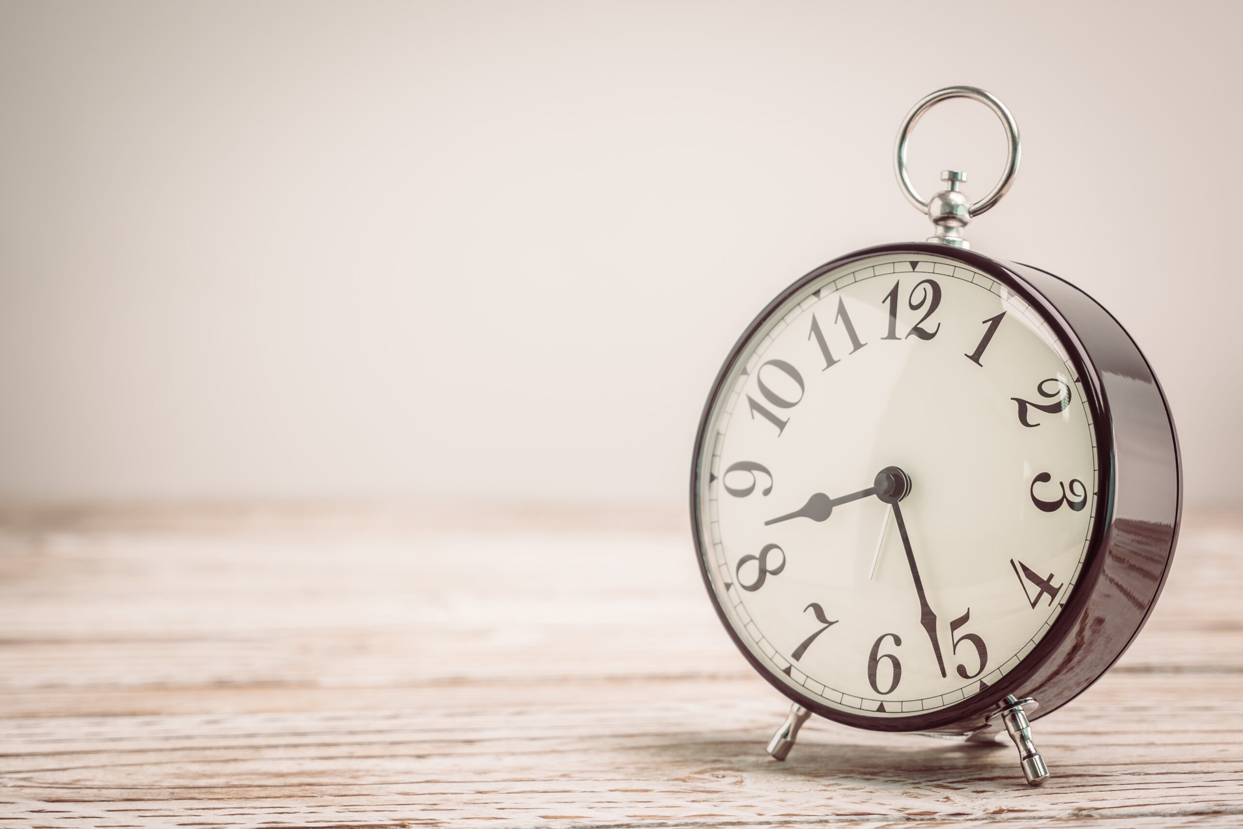 A vintage clock rests in a quiet, white room.