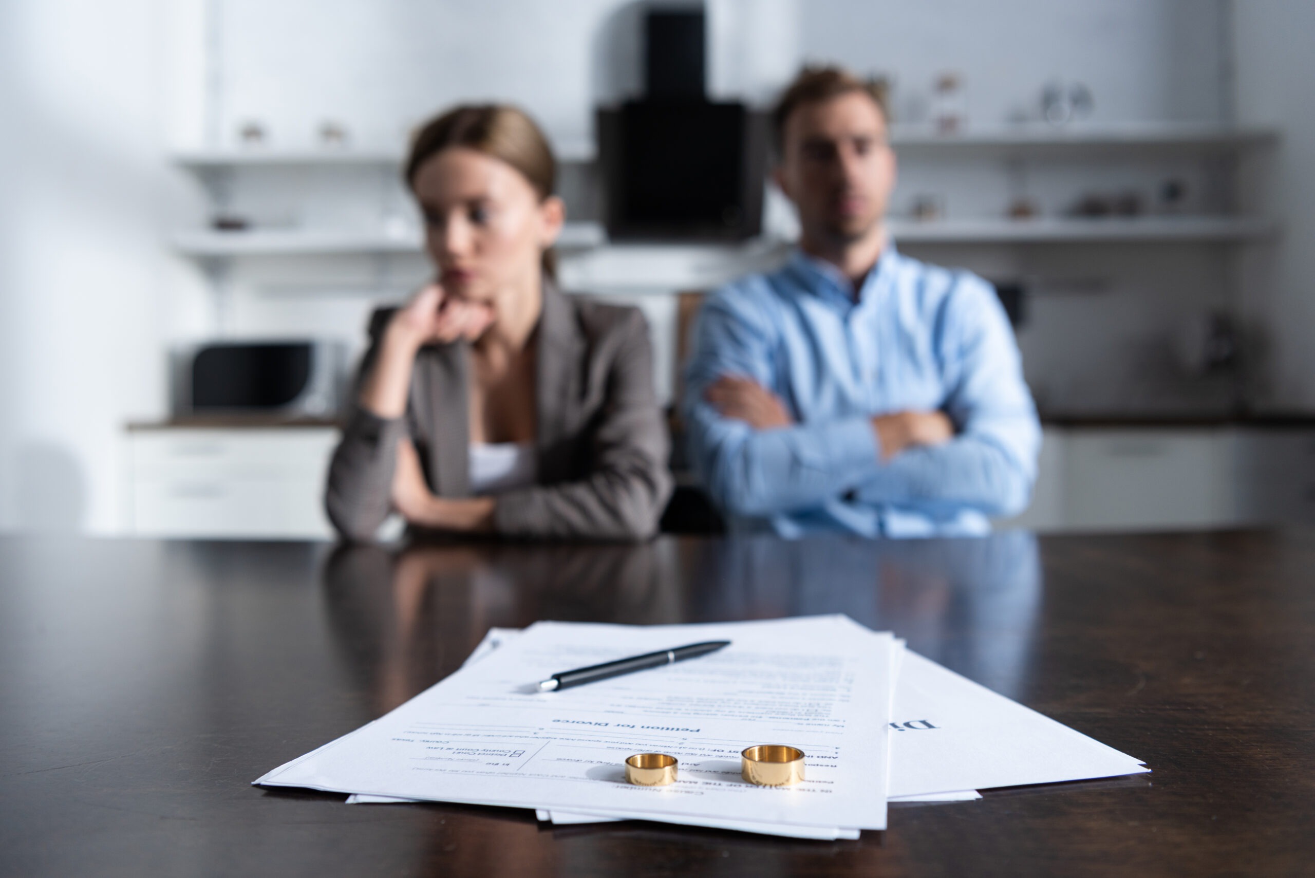 Couple sitting at table with documents at early stage of divorce process.
